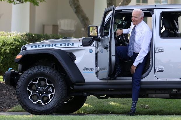 US President Joe Biden hops out after test driving a Jeep Wrangler 4xe Rubicon during an event for clean cars and trucks, and signs an executive order on transforming the country&rsquo;s auto fleet at the White House. Photo: Reuters