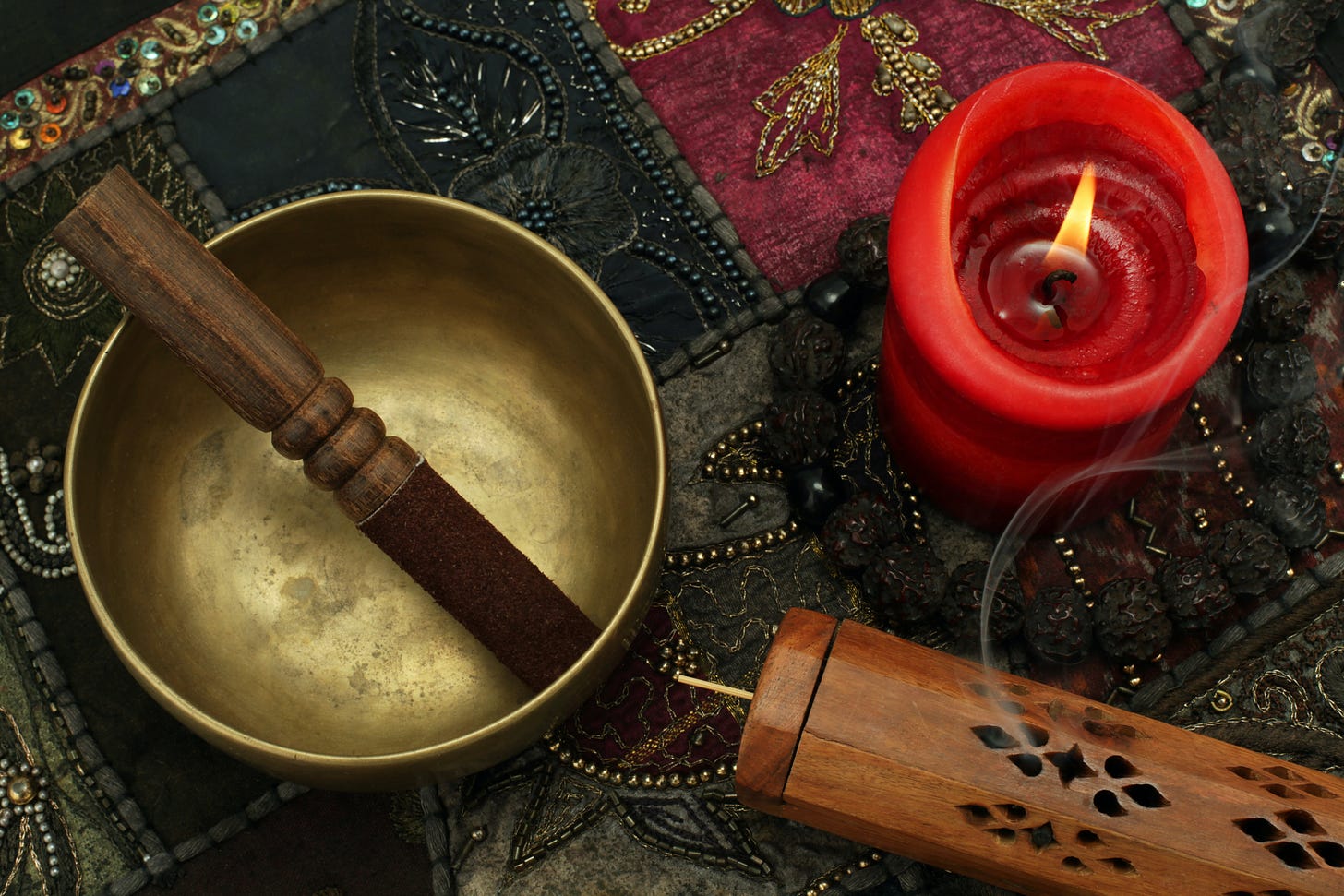 singing bowl, a red candle on a tapestry