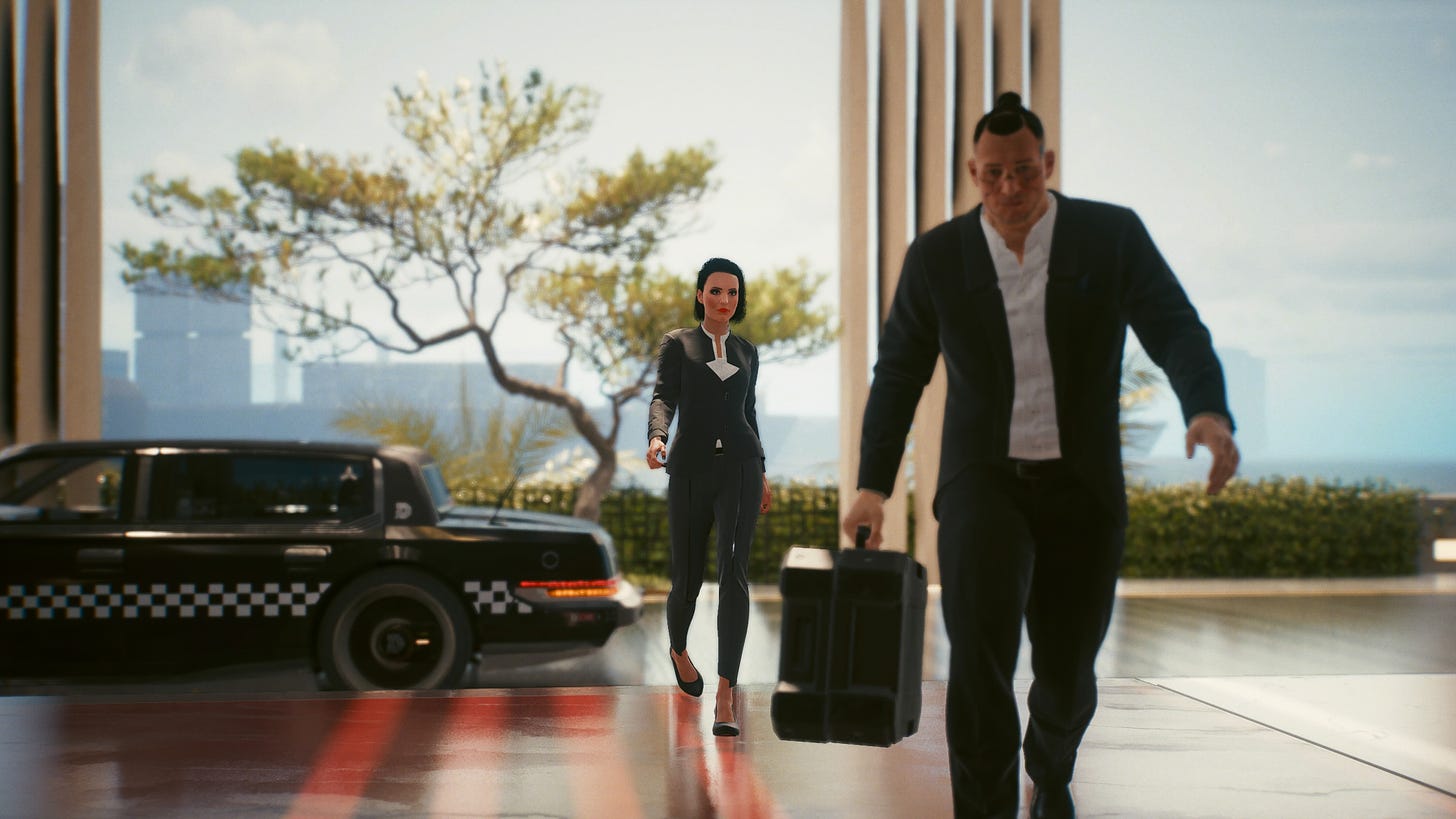 Two characters are walking towards the camera, coming from a car that parks to the left. V, dressed in a fanzy blazer, is in the middle, while a grim looking man is carrying a big suitcase to the right.