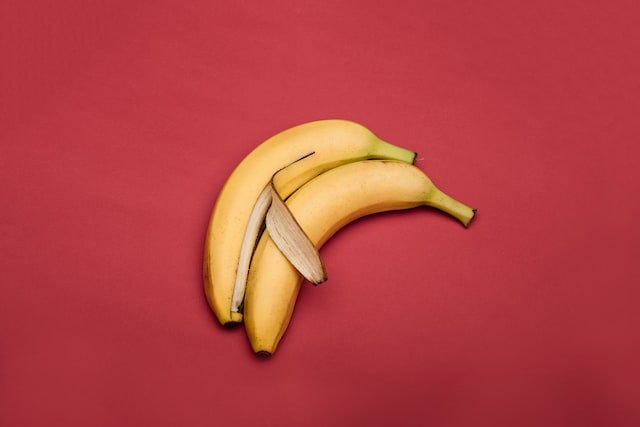 Two bananas spooning on a red background