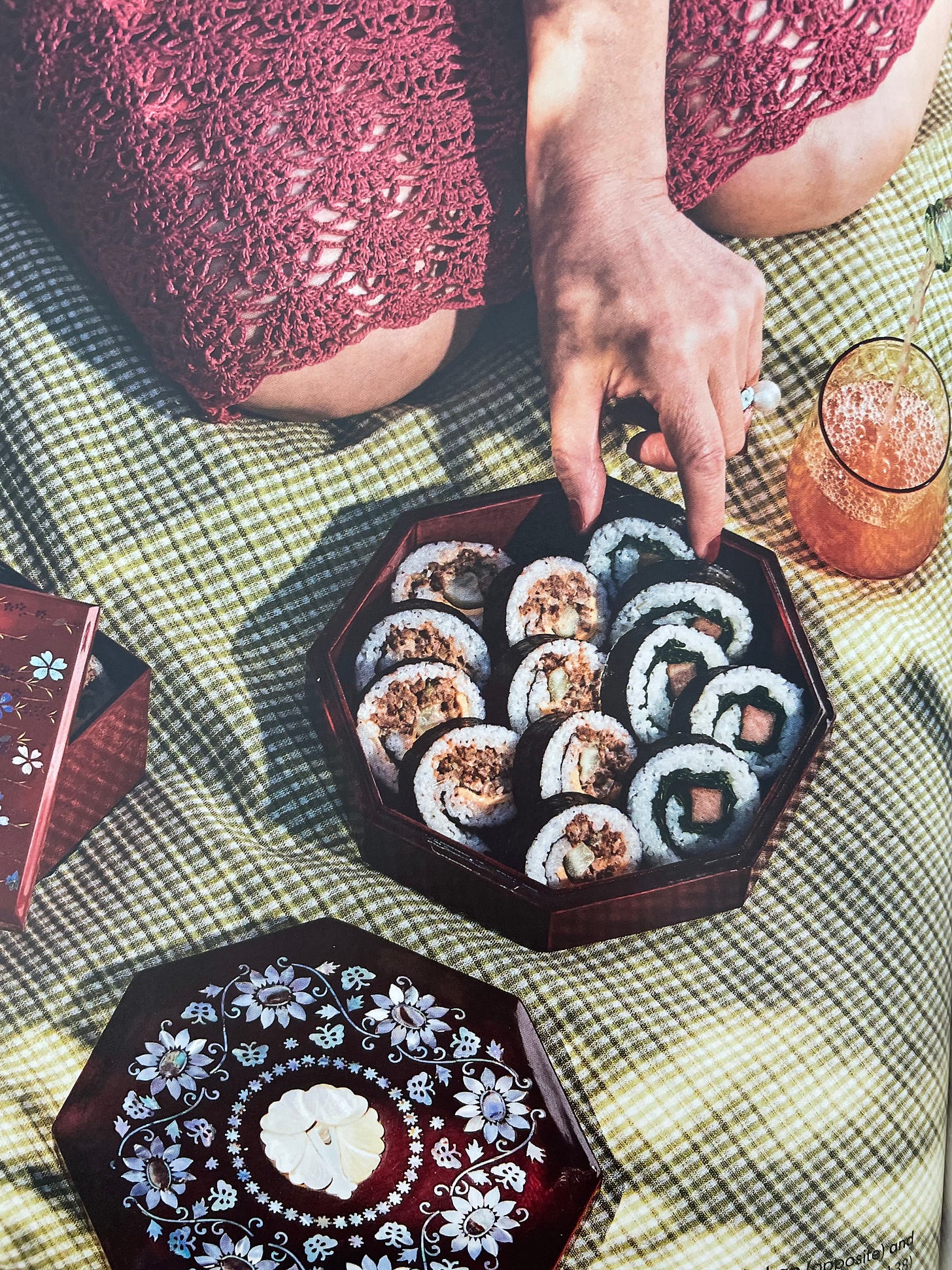 Kimbap in a decorative box on a picnic blanket