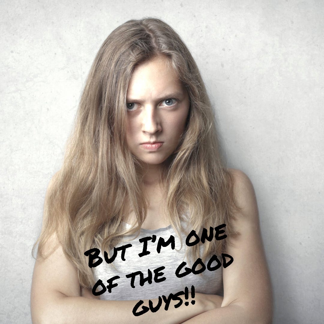 Photo of a mid-twenties young woman with long hair. She has her arms crossed and is looking belligerently at the camera with her head lowered. Across the front of the picture is text that says "But I'm one of the good guys!!"