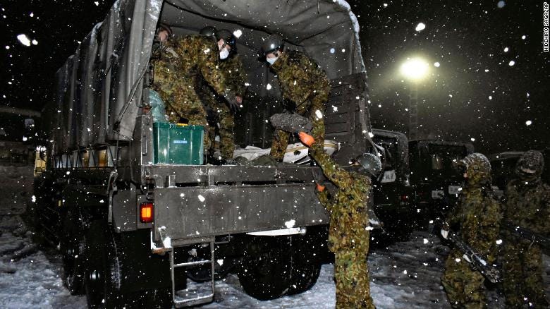 Japan Self-Defense Forces personnel prepare food and water for people stuck on Kanetsu expressway on December 17.