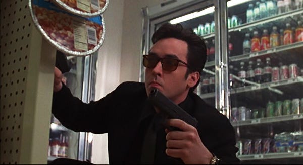 Professional assassin Martin Blank (John Cusack) takes cover in a convenience store shootout in "Grosse Pointe Blank," a 1997 comedy from Hollywood Pictures.