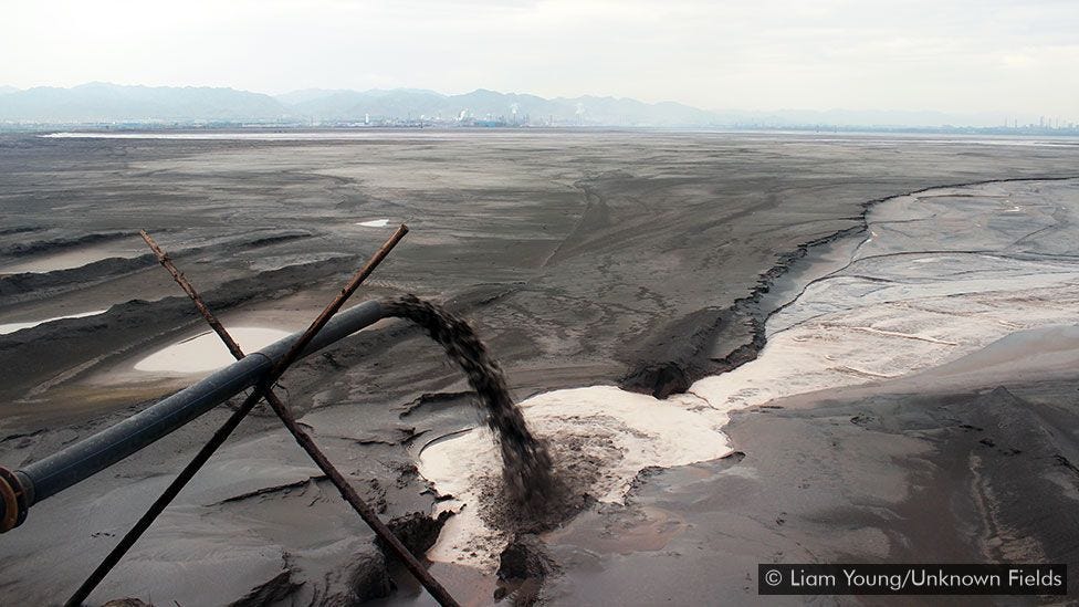 Black sludge pours into the lake - one of many pipes lining the shore (Credit: Liam Young/Unknown Fields)
