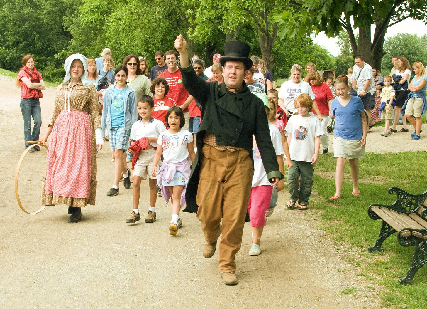 Wearing a top hat and tailcoat, I'm leading a group of 30 museum guests down a dirt road after a museum theater performace.