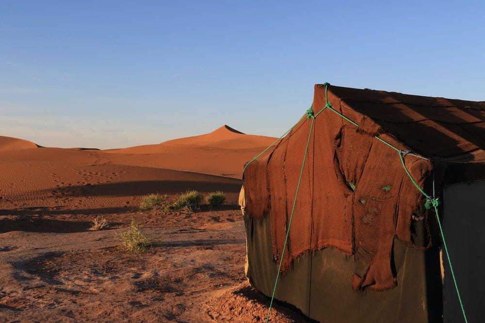 brown and white tent on brown field during daytime