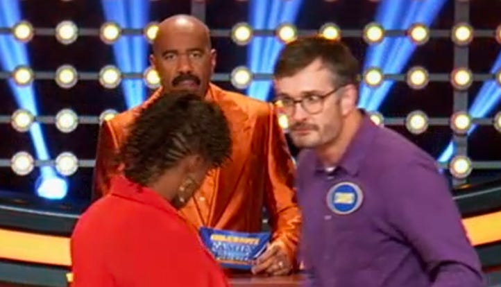 Me shooting a death stare at my opponent on Family Feud, as host Steve Harvey does his thing on the background!