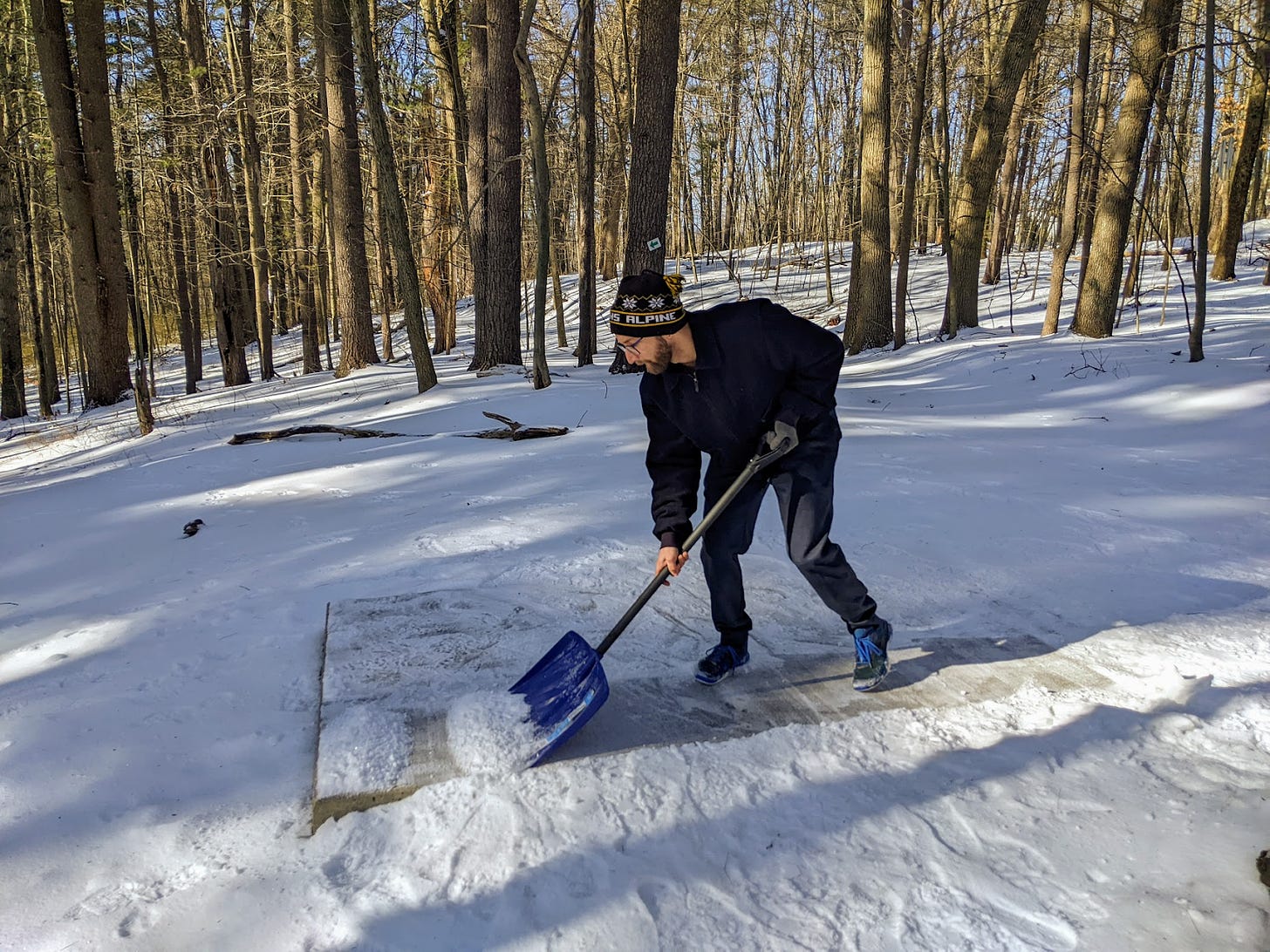 Ben shoveling the tee pad at hole 2. Hollows North Disc Golf Course, Manchester, New Hampshire.