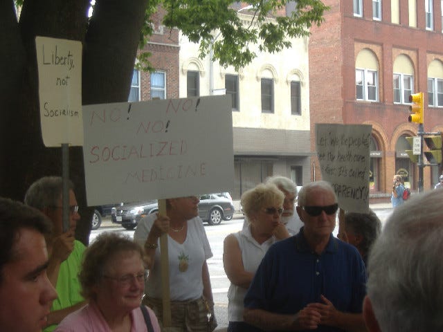 More good signage. If you can't read the sign on the right it says 'Let we the people see the healthcare bill first. It's called TRANSPARENCY!'