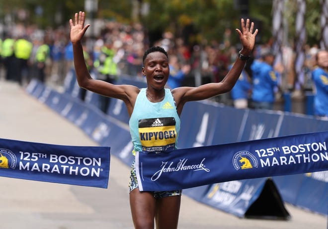 Diana Kipyogei of Kenya crosses the finish line to win the 2021 Boston Marathon.