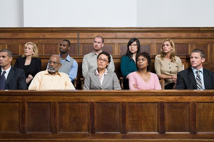 A jury sits in the courtroom.