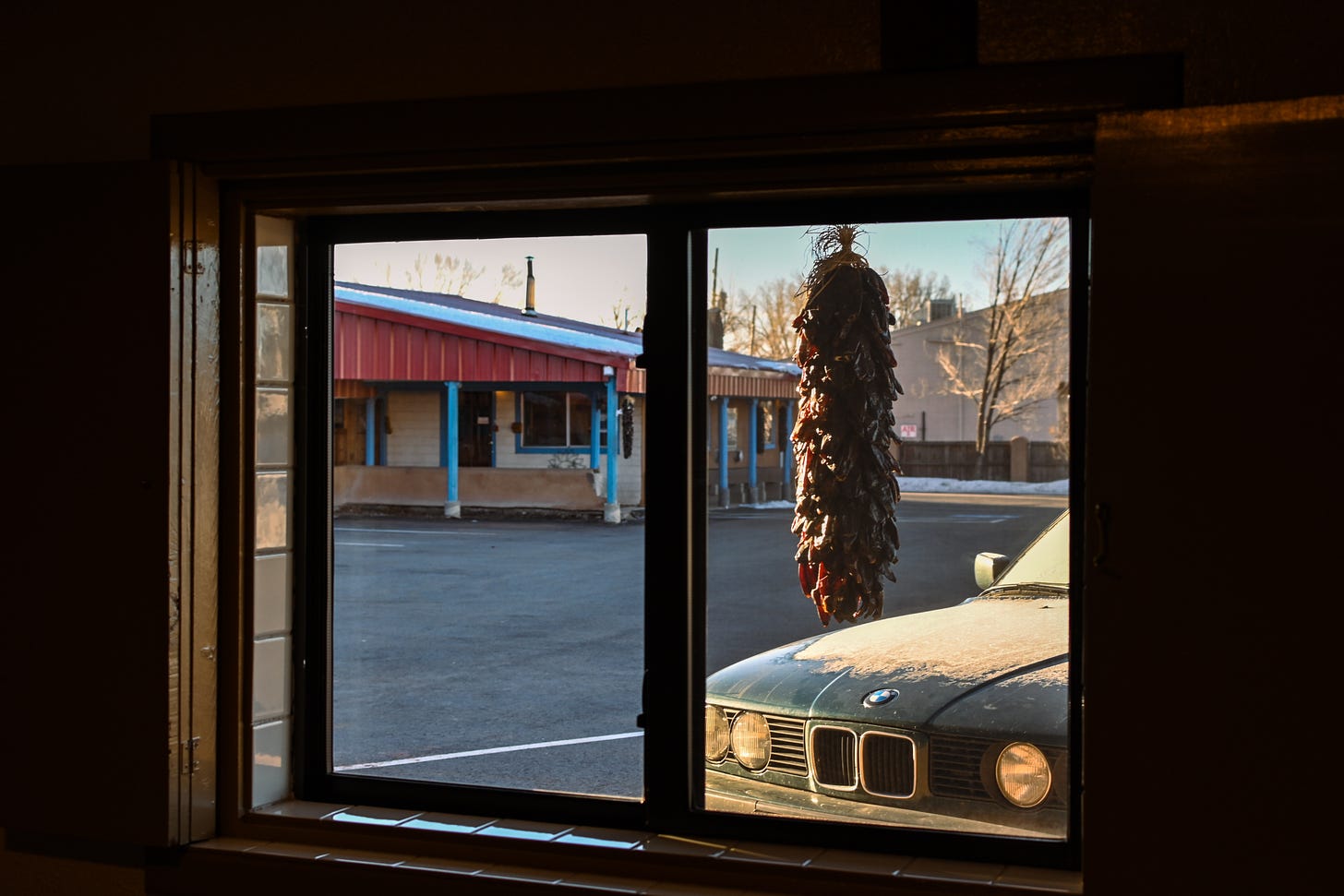 Looking out the motel window, a bundle of chilli peppers hangs from the overhang.