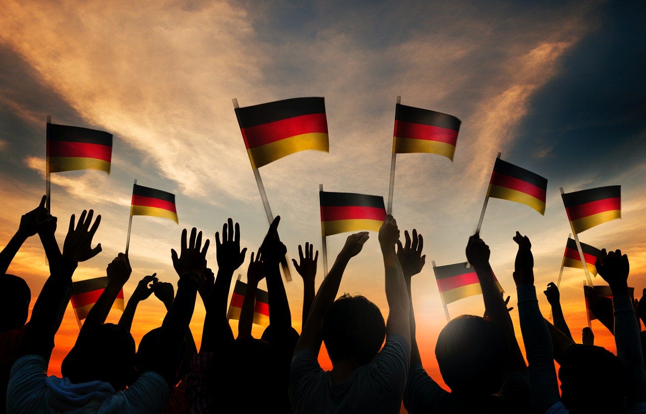 Silhouettes of People Holding the Flag of Germany
