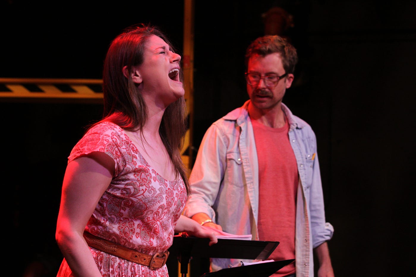 A woman screaming in pain while a man looks on.