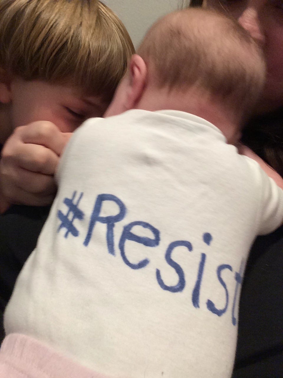 picture of a baby onesie that says #resist