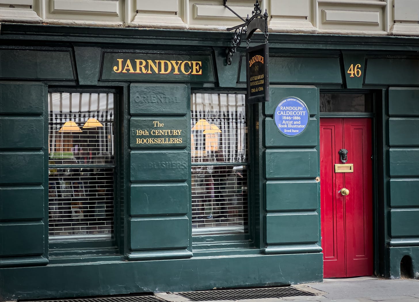 The Jarndyce Book Store in London England, a hunter green wooden building with a deep red door