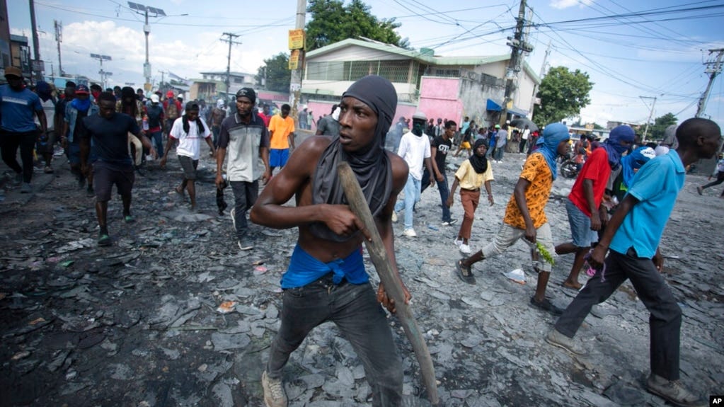FILE - A protester carries a piece of wood simulating a weapon during a protest demanding the resignation of Prime Minister Ariel Henry, in the Petion-Ville area of Port-au-Prince, Haiti, Oct. 3, 2022.