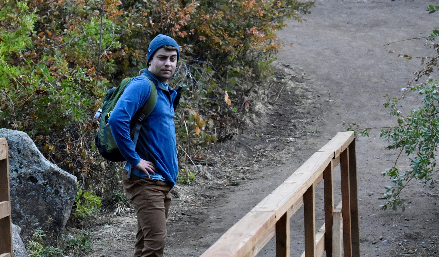 me, modeling my blue quarter zip on a bridge at a river crossing