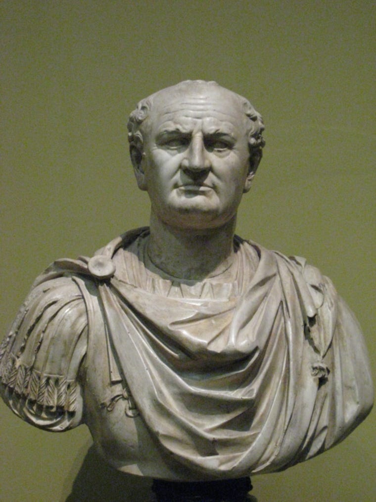 Front view of a bust. He is balding and wears a Roman tunic.