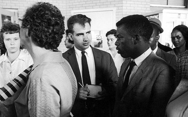 Writer Calvin Trillin, center, interviewing John Lewis in Birmingham, Ala., as the Freedom Riders were boarding the bus for Montgomery in 1961 (Donald Uhrbrock/The LIFE Images Collection/Getty Images via JTA)