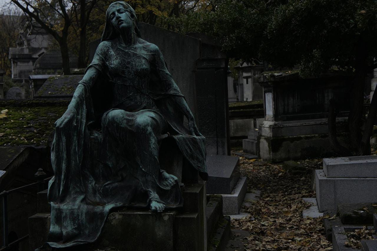 Statue of mourning woman in a Paris graveyard.