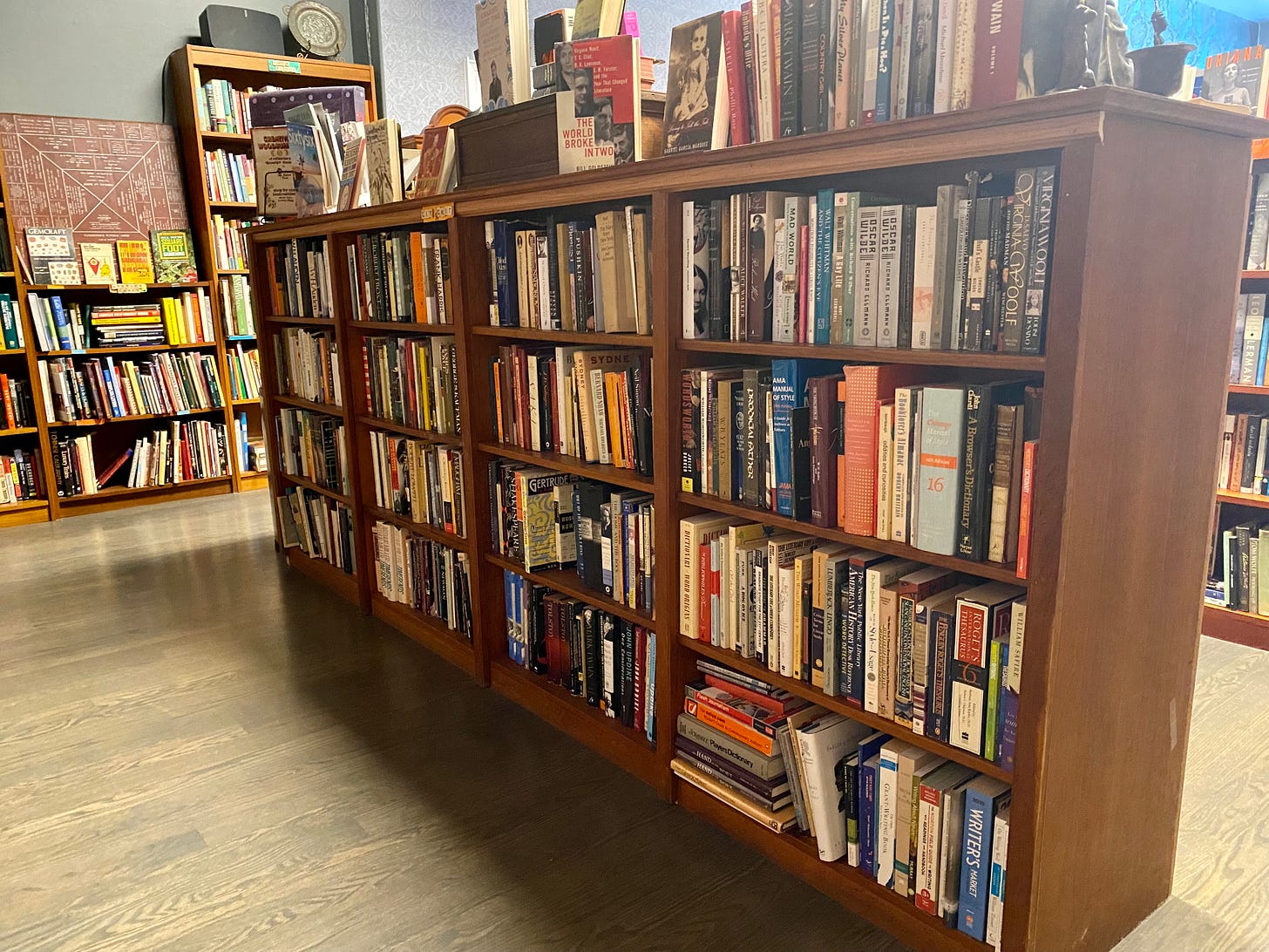 A long, low full bookcase, the contents of which are described below