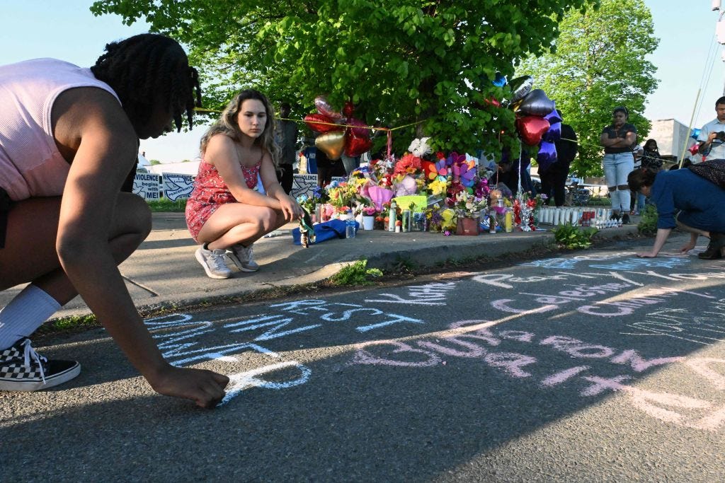 People leave messages at a makeshift memorial near a Tops grocery store in Buffalo, NY, the day after a gunman killed 10 people. (Usman Khan / Getty Images)