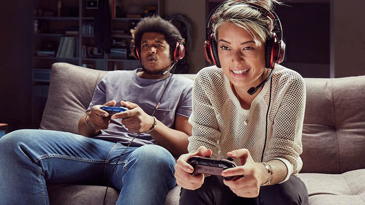 Two players holding Xbox controllers and wearing headsets