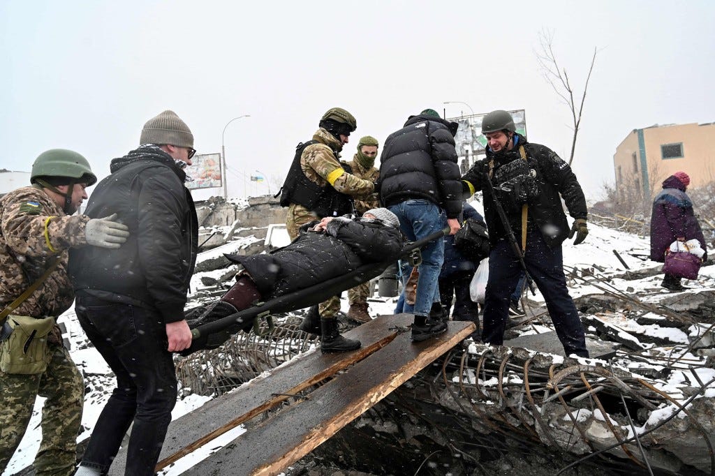 Medics carry a wounded woman during the evacuation.