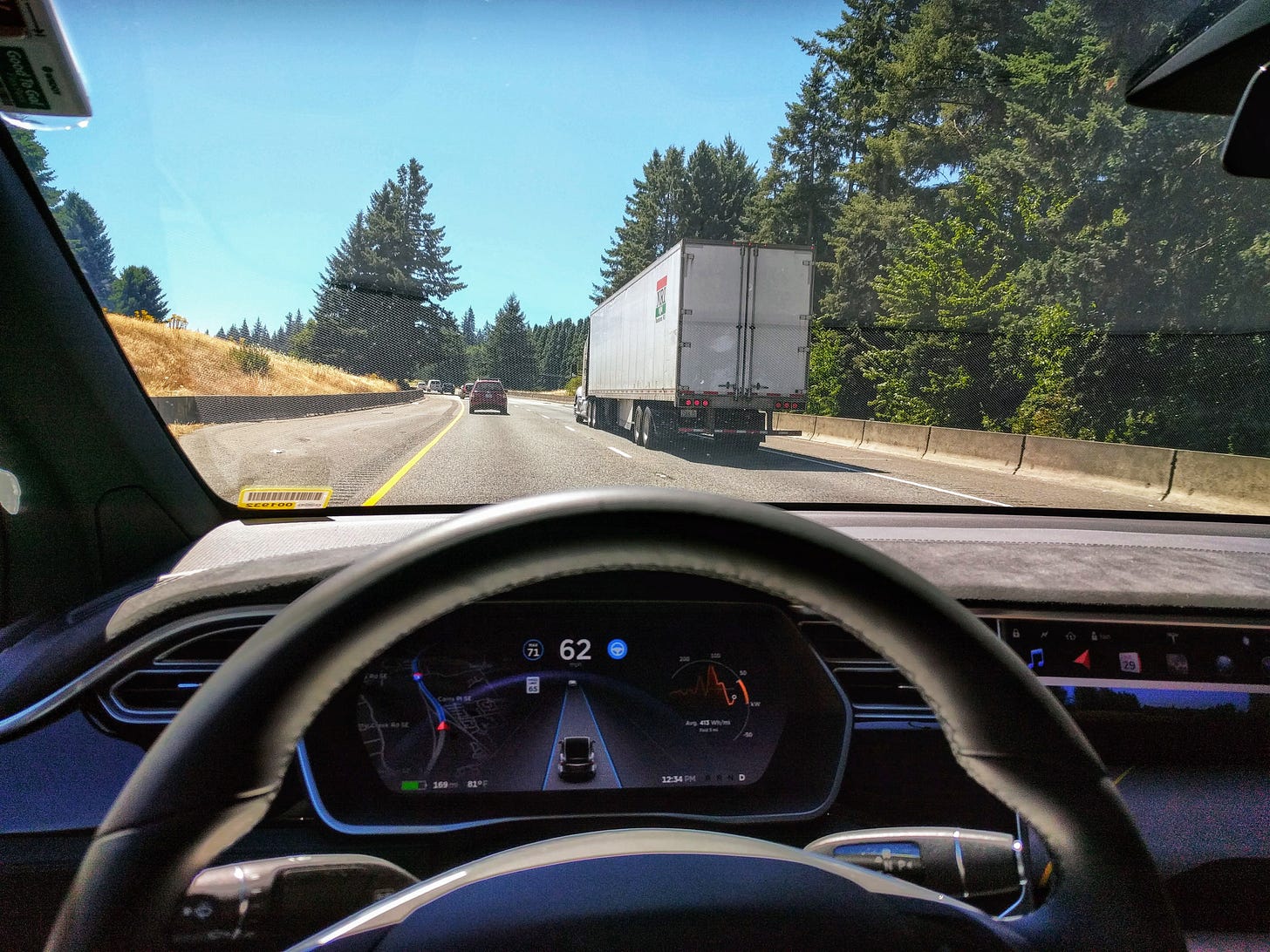 A picture of a US highway, behind a truck, from a Tesla Model X. Autopilot is on