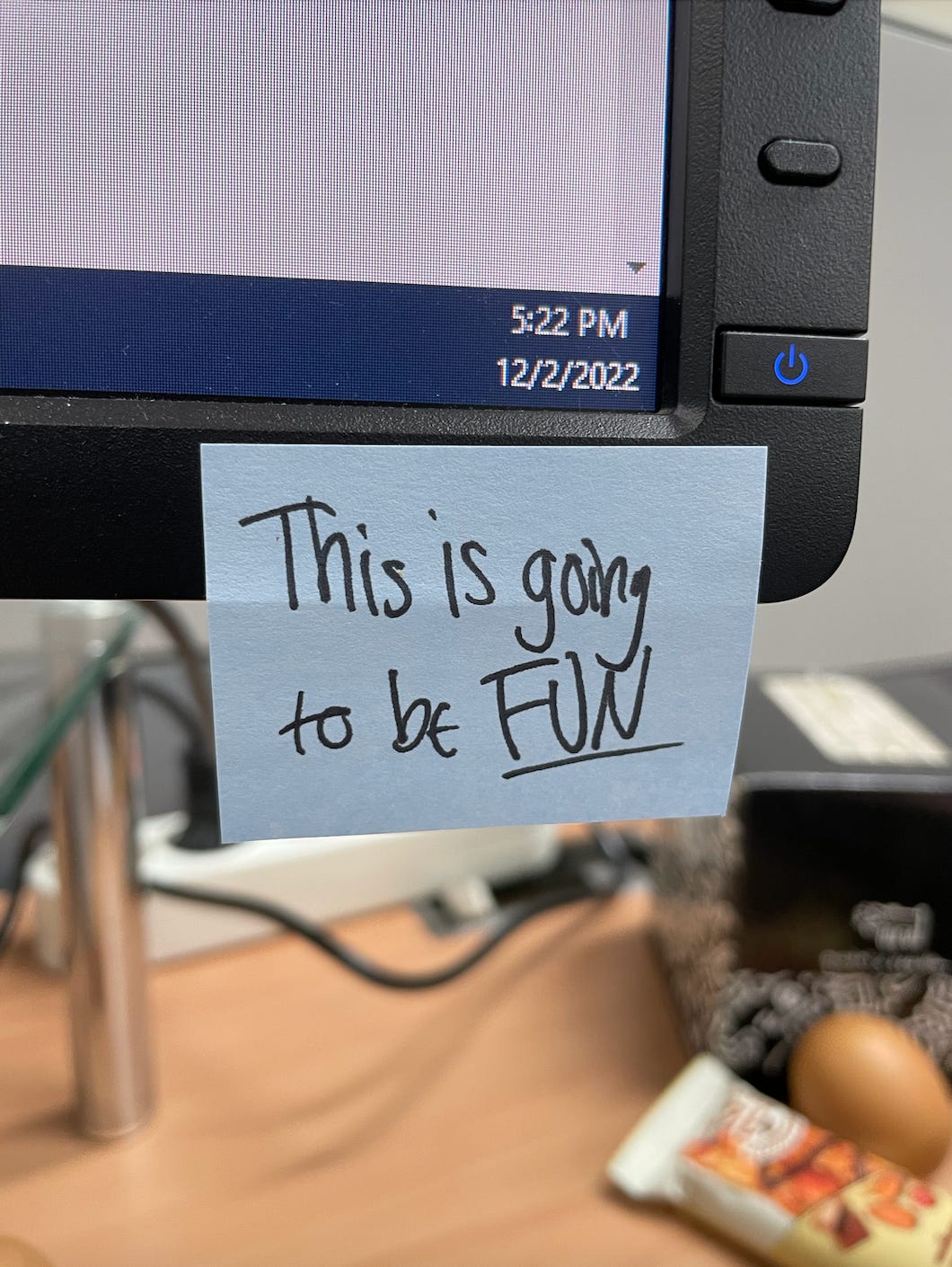 A photo of Kat's computer monitor. A post-it note is stuck to the screen. It says, "This is going to be fun."