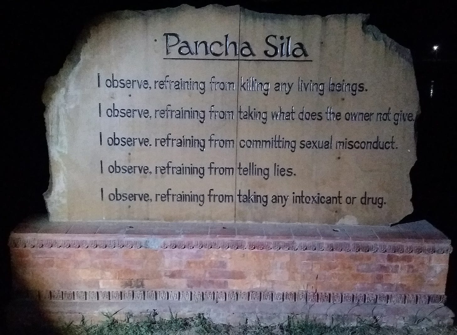Stone plaque with five precepts shortly described in English, engraved in the stone.