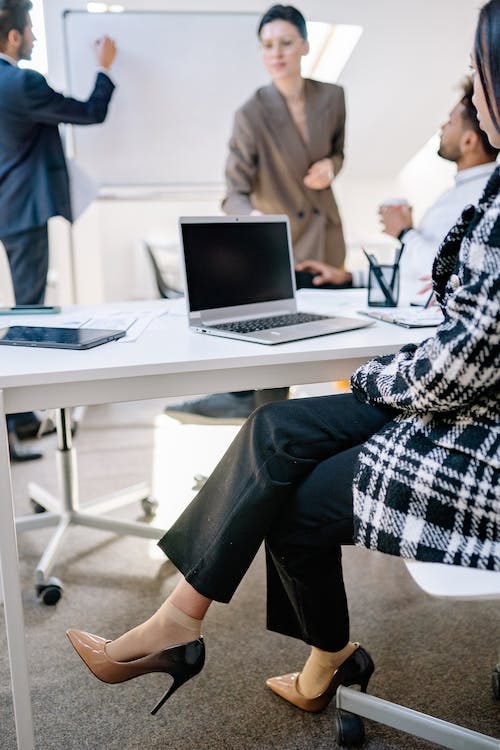 Free Woman in Black and White Plaid Dress Shirt and Black Pants Sitting on Chair Stock Photo