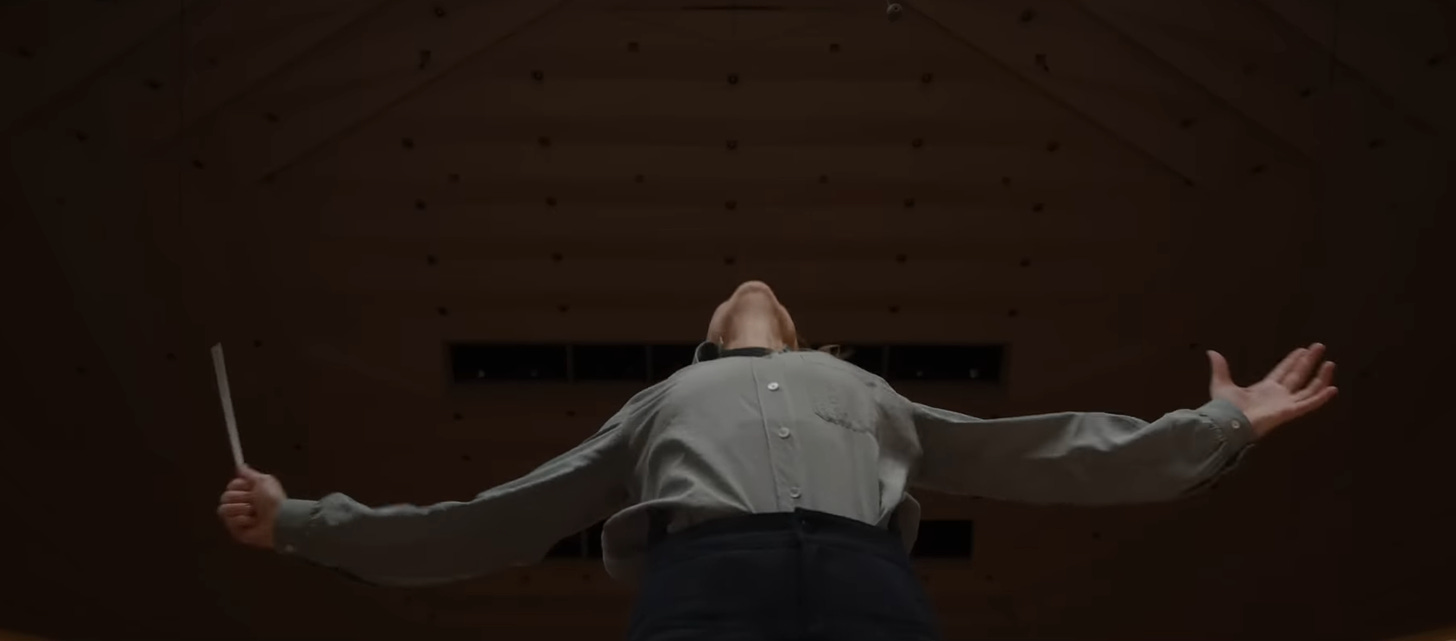 A shot from below of Cate Blanchett in Tar, conducting with her arms spread outward.