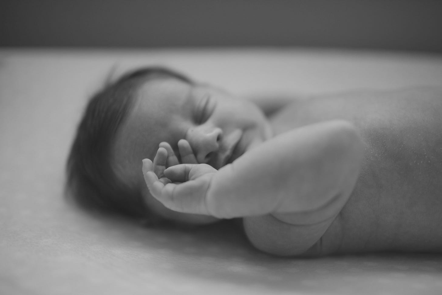 Image of a new born baby rubbing his face