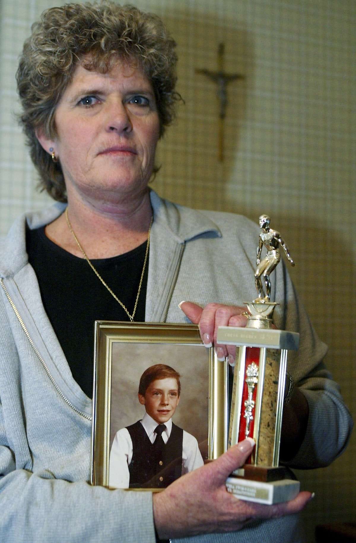 Mary Ann Hughes, poses with a photo of her late son Christopher, then six, Friday Jan.30, 2004, at her home in Chino Hills, Calif. On a June night in 1983, her son Christopher was having a sleepover at the sprawling, hill-top Chino Hills home of Douglas and Peggy Ryen with their two children, Jessica, 10, and Joshua, 8, when they were attacked by someone using a hatchet and a knife. Twenty-one years later, she said she has reserved seats to the convicted killer's execution. And she's keeping her fingers crossed last ditch efforts by celebrities such as Denzel Washington and Mike Farrell to keep Kevin Cooper alive won't get his Feb. 10 execution date postponed.(AP Photo/Damian Dovarganes) Mary Ann Hughes shows a photo of her son, Chris, 6 years old when the picture was taken, at her home in Chino Hills (San Bernardino County). Chris and three others were killed in June 1983.