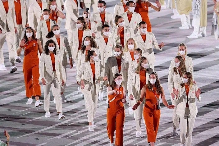 <p>Are the delegates from Netherlands heading to the opening ceremony or to the office? Some delegates wore belted burnt orange (the national color) and cream sleeveless jumpsuits, while others wore pinstripe suits. </p>