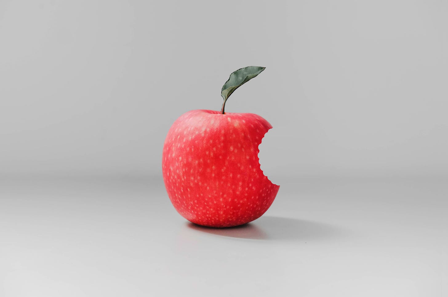 Image of a red apple with a bite stolen from it.