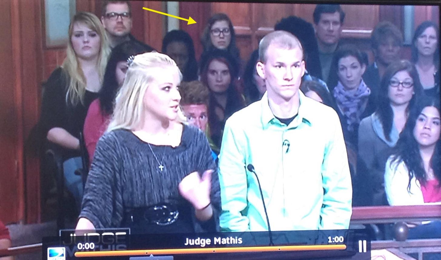 The audience in the background of an episode of Judge Mathis, with a yellow arrow pointing at the author