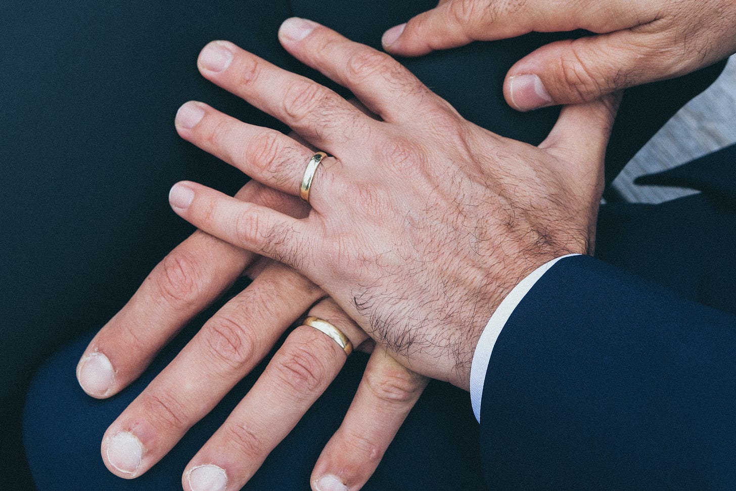 Two men's hands with wedding rings