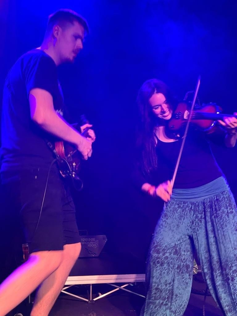 May be an image of 2 people, people standing, people playing musical instruments and indoor