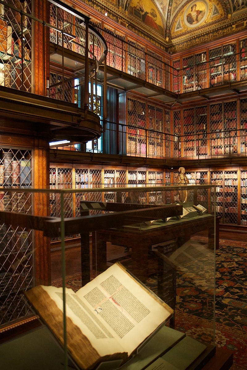 A glass case holds an open book in a library A glass case holds an open book in a library