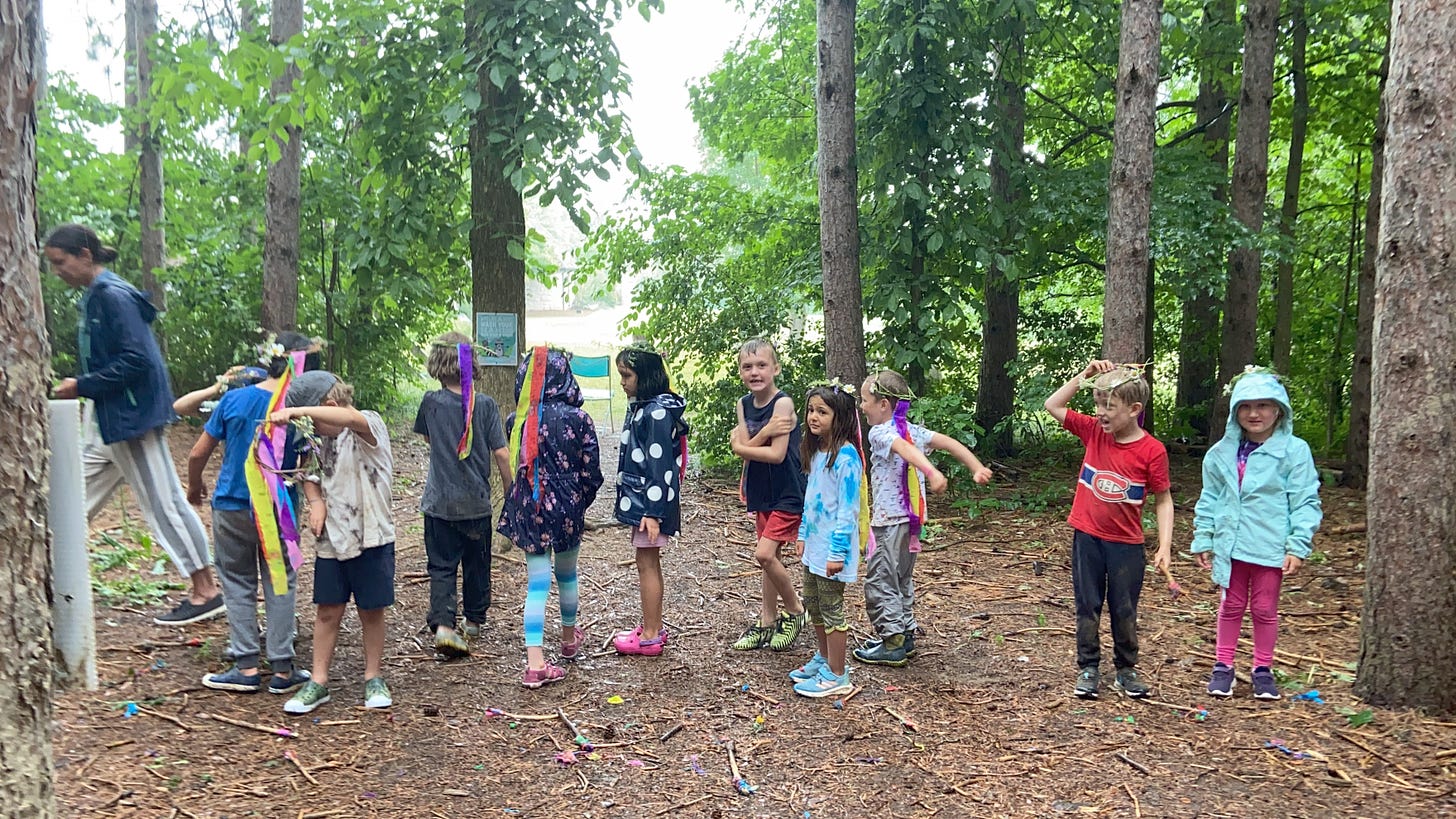 Children standing in a line amidst the forest.