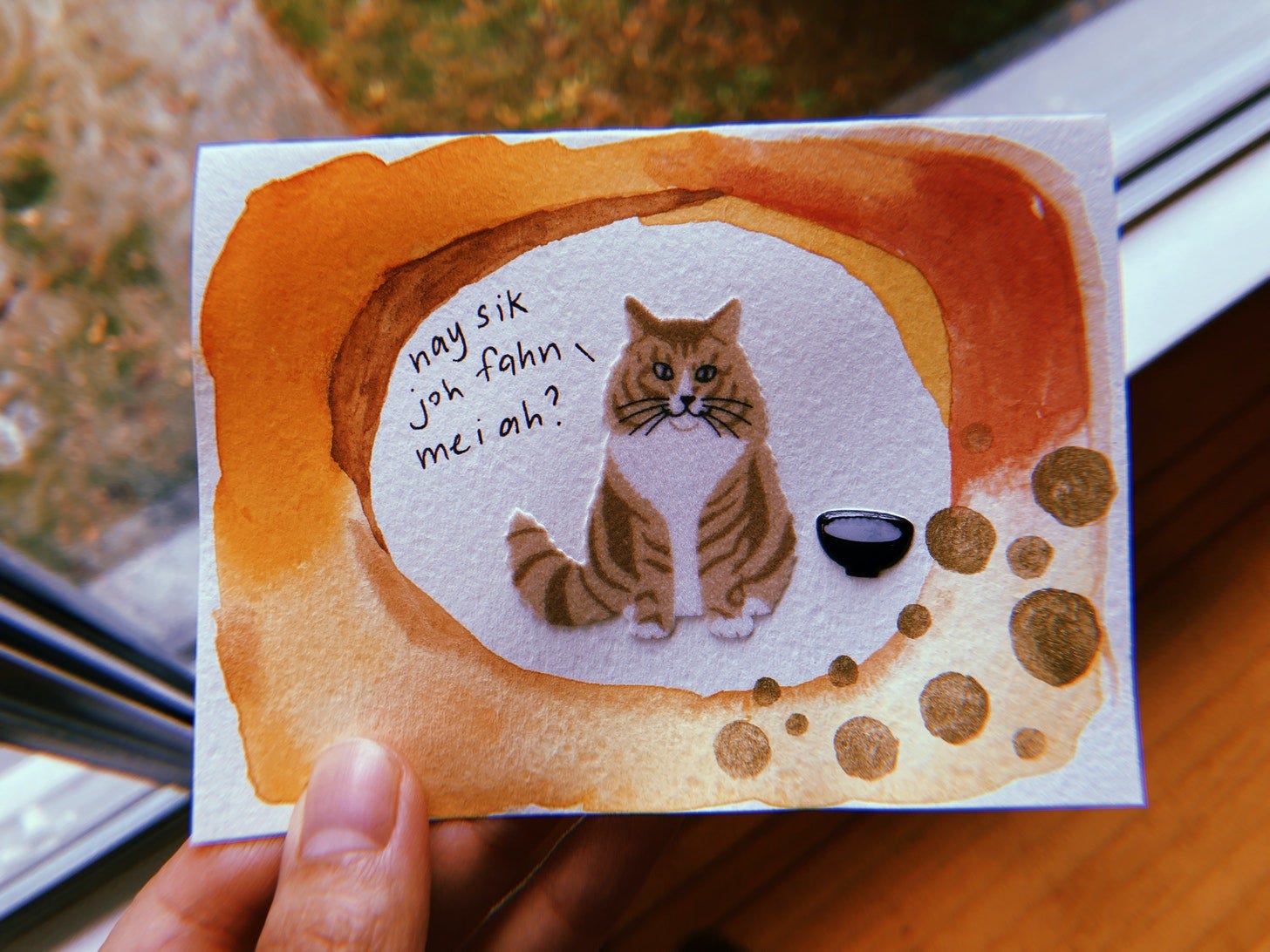 Watercolour card painted with an orange border in the middle is a cat asking in Cantonese, "nay sik joh fahn mei ah" which translates literally to, have you eaten rice? or How are you?