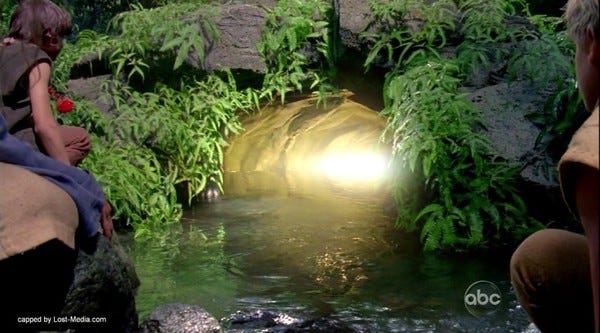 A river runs into a cave from which emits a warm golden glow. On either side of the river Brother and Jacob look into the light.