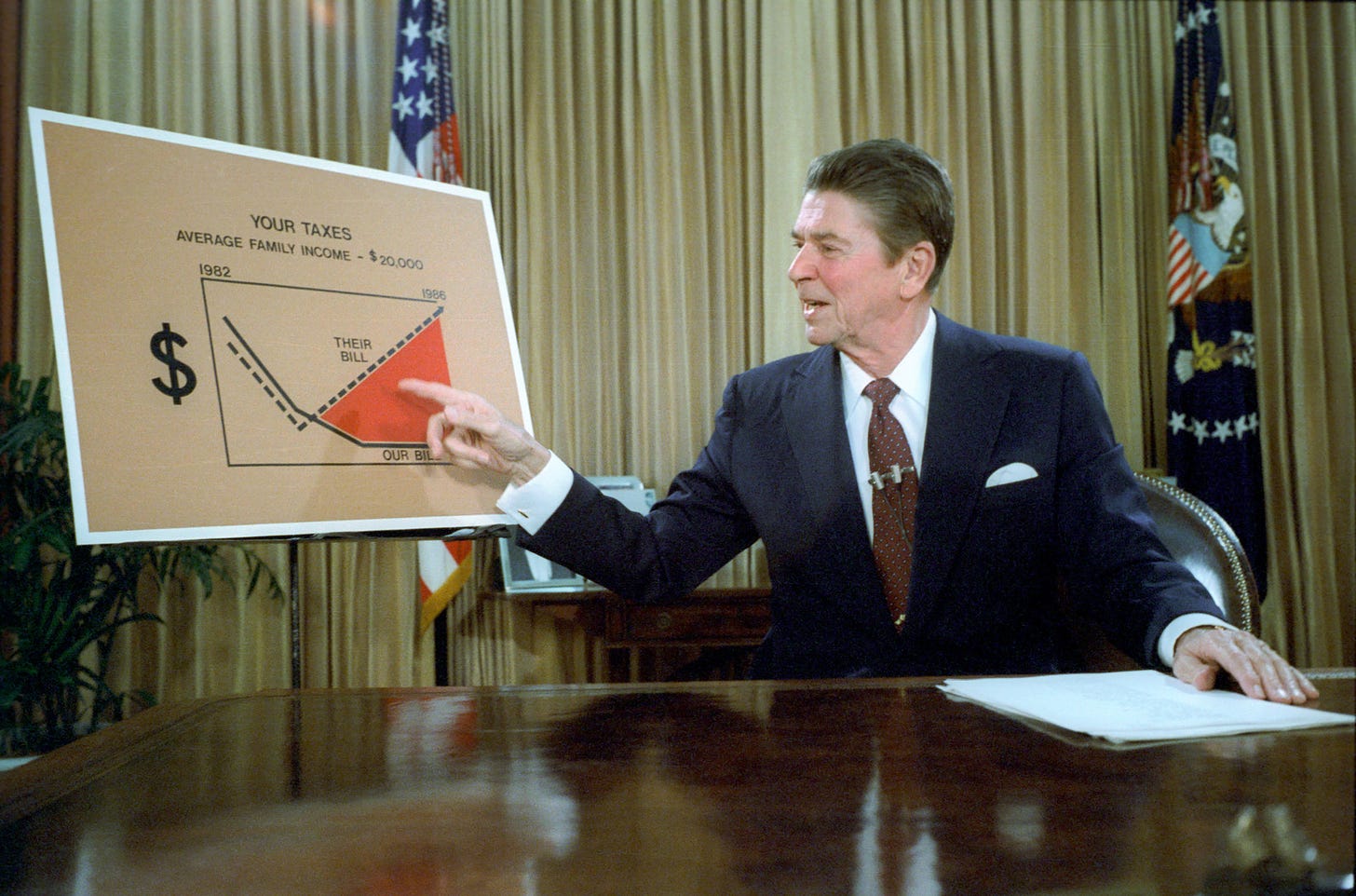 A picture of President Ronald Reagan using a graph to explain Reaganomics