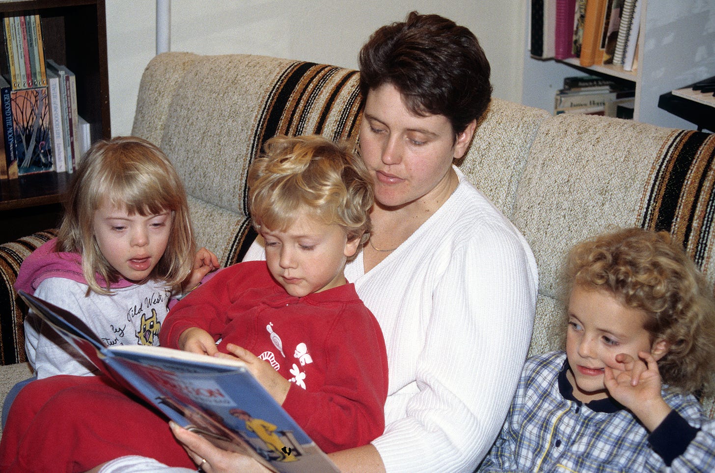 Mom reading to three kids