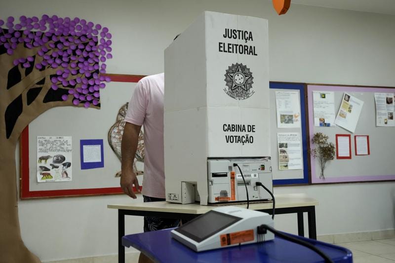 An electoral worker installs an electronic voting machine at a polling station in preparation for the presidential run-off election, in Brasilia, Brazil, Saturday, Oct. 29, 2022. On Sunday, Brazilians head to the voting booth again to choose between former President Luiz Inacio Lula da Silva and incumbent Jair Bolsonaro, who are facing each other in a runoff vote after neither got enough support to win outright in the Oct. 2 general election.  (AP Photo/Eraldo Peres)