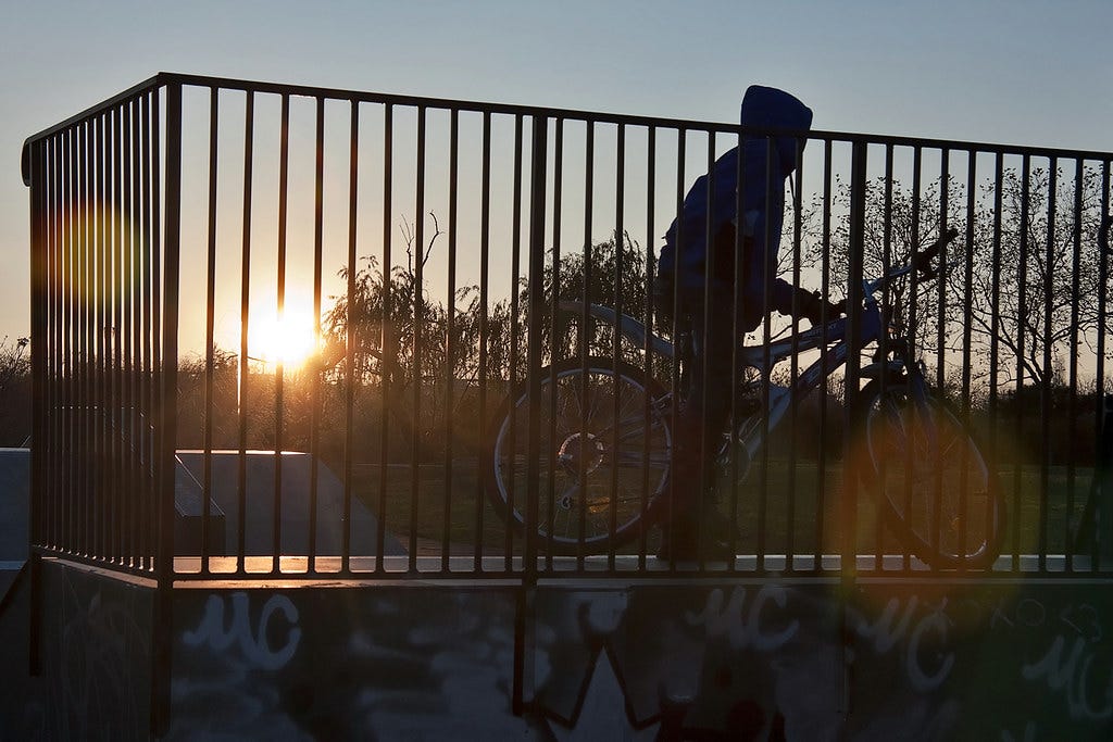 Teenager on mountain bike over mini ramp